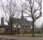 Achterzijde kapel met vijfzijdig koor en een met koper beklede dakruiter.
<br/>
Corrie Groen- Pickhard, 2015-01-25